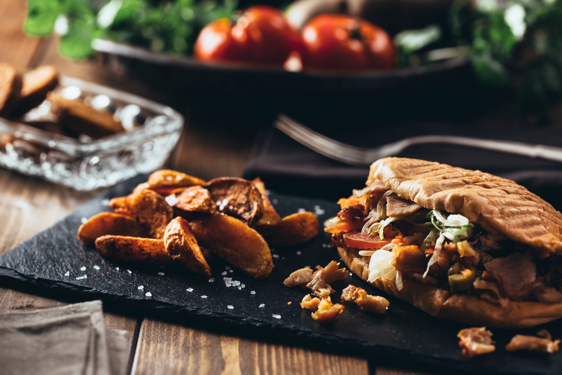 Doner kebab with fried potato on served wooden table. Vintage edition.